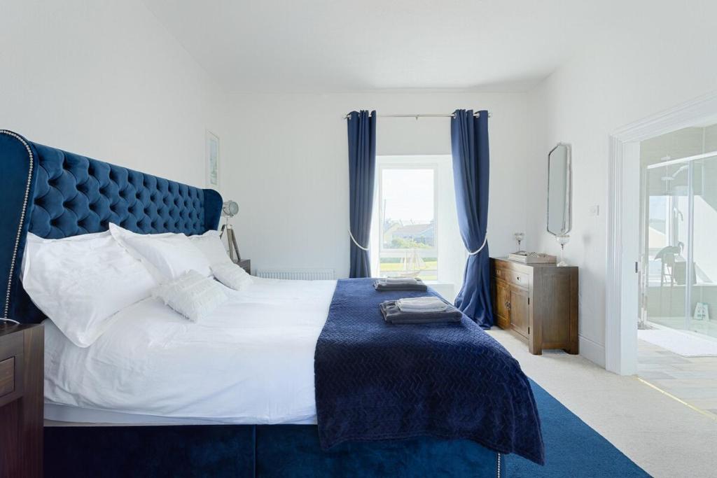利斯坎诺Holland House No1的一间卧室配有一张大床和蓝色床头板