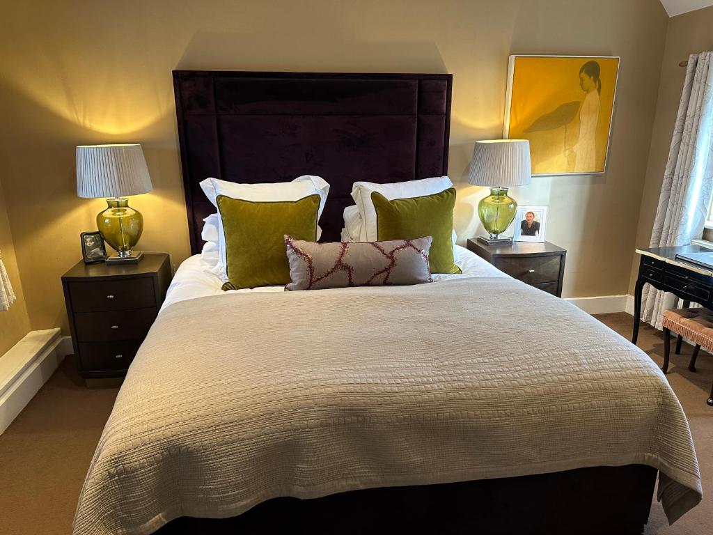 BlewburyThe Red Lion的一间卧室配有一张带绿色枕头的大床
