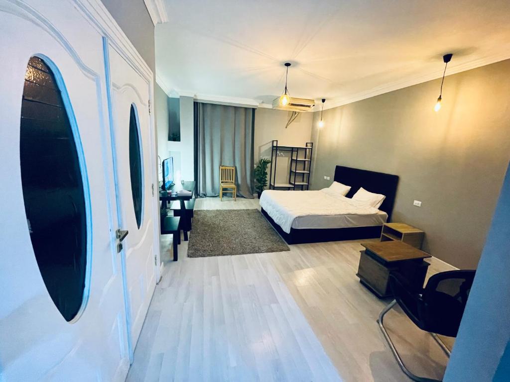 开罗Rove Residence New Cairo的一间卧室配有一张床和一张书桌,另一间卧室配有一张桌子。