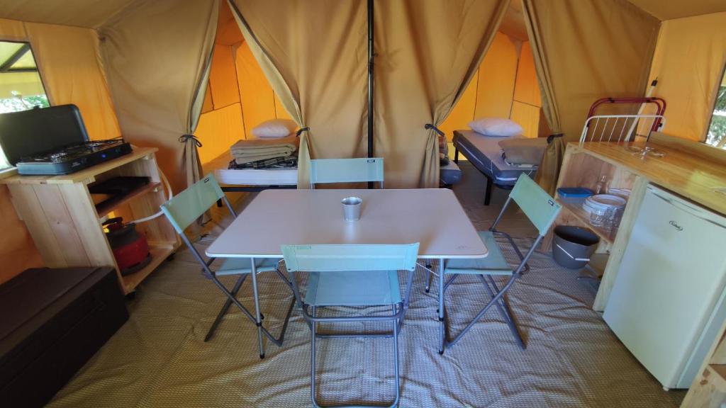 NançayCamping ONLYCAMP LES PINS的帐篷内配有白色的桌椅