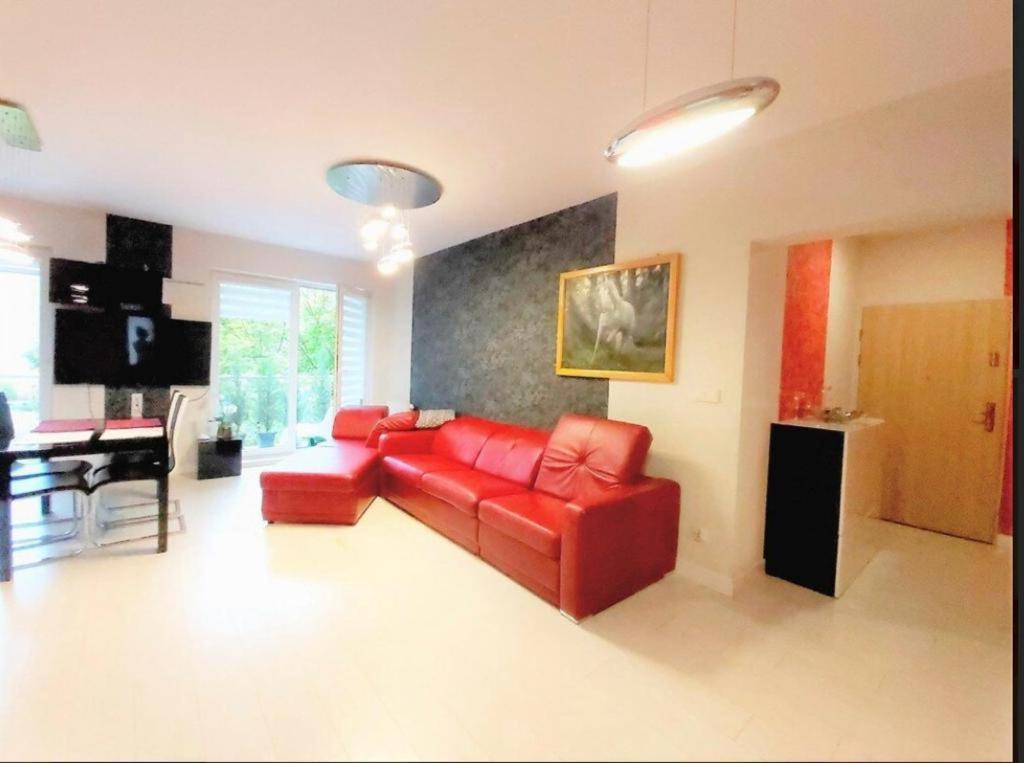 弗罗茨瓦夫ApartamentKosciuszki的客厅配有红色的沙发和桌子