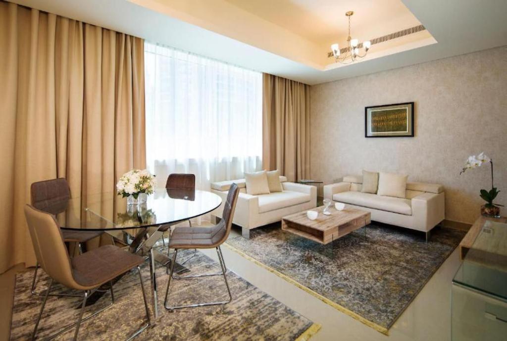 迪拜Marina One Bedroom - KV Hotels的客厅配有桌子和沙发