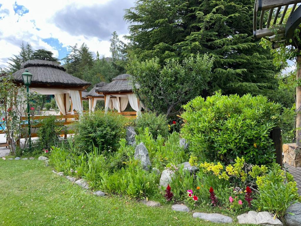 波特雷里约斯El Carmelo Mountain Lodge的花园设有两个凉亭和鲜花