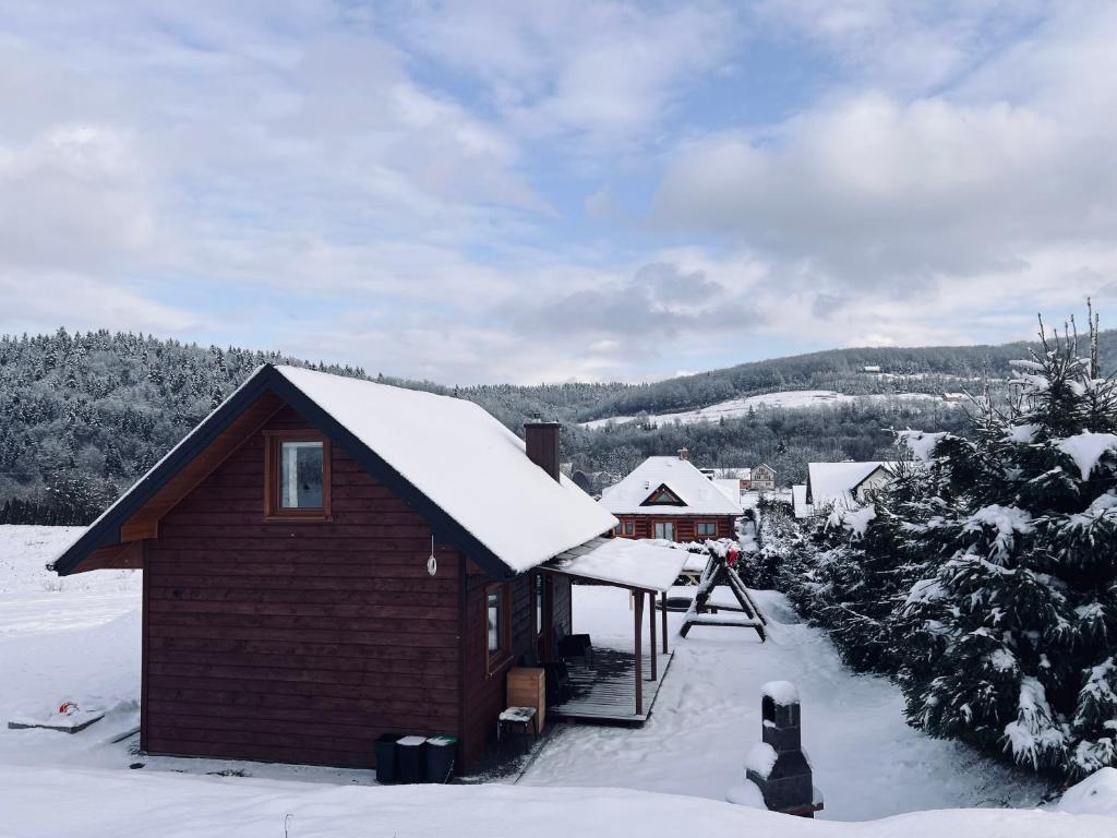 巴利格鲁德Domek na Słonecznym Pagórku的屋顶上积雪的小小屋