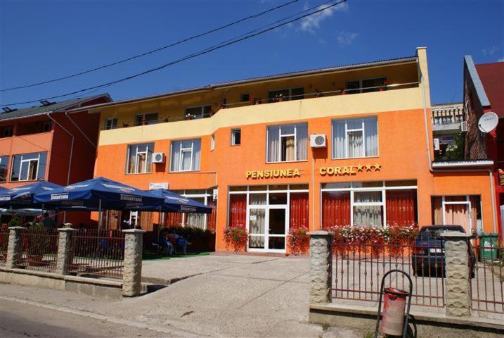 巴亚马雷Pension Coral的一座橙色的建筑,街上有一间餐厅