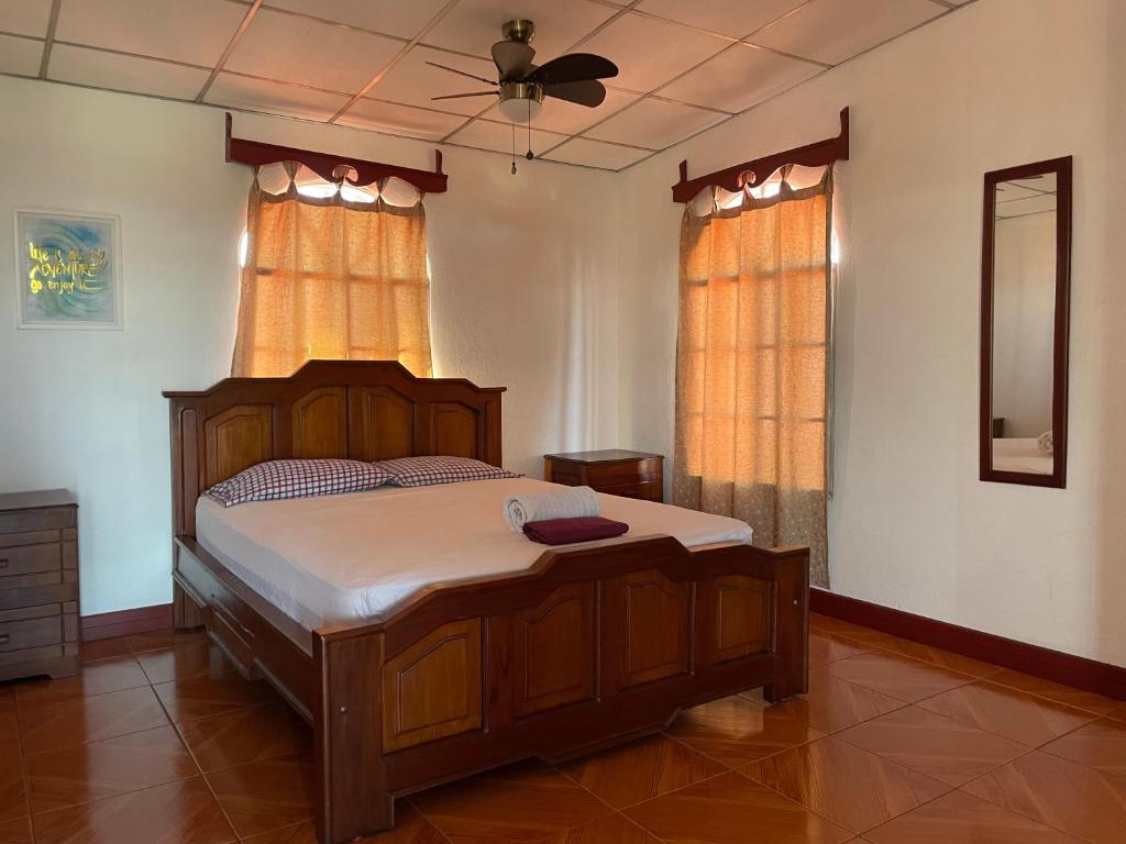 马那瓜Casa Robles - Your Stay Near Airport的一间卧室配有一张木床和吊扇