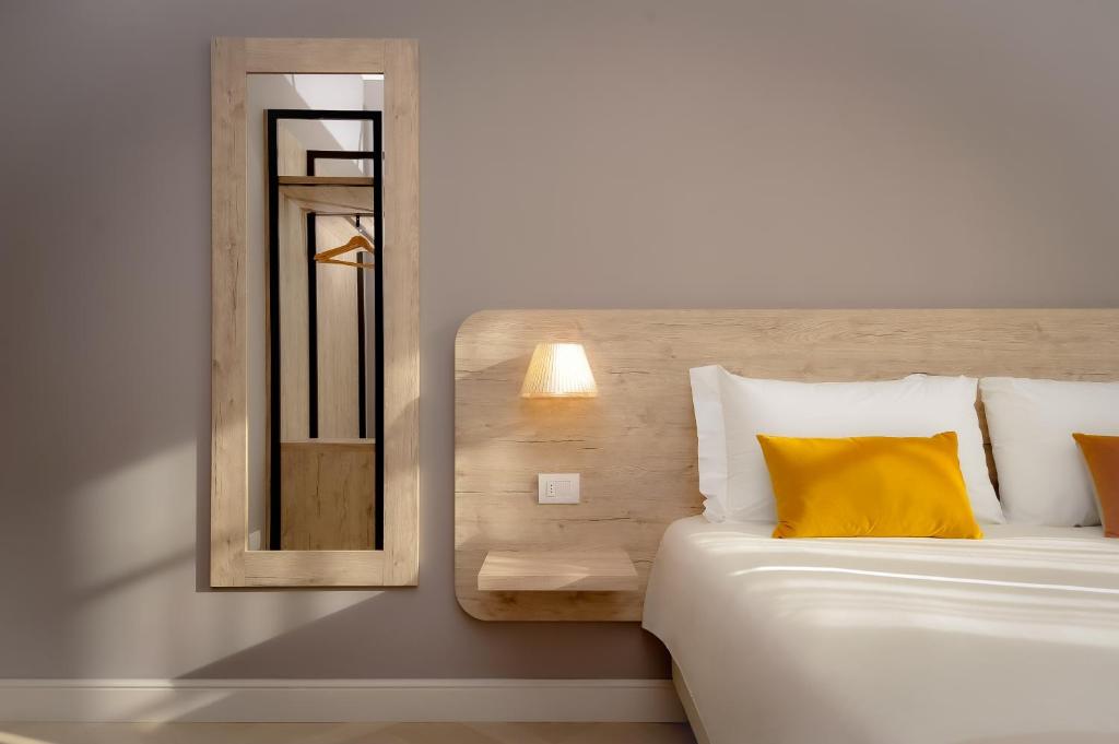 贝加莫Bergamo Inn 43的一间卧室配有一张带黄色枕头和镜子的床