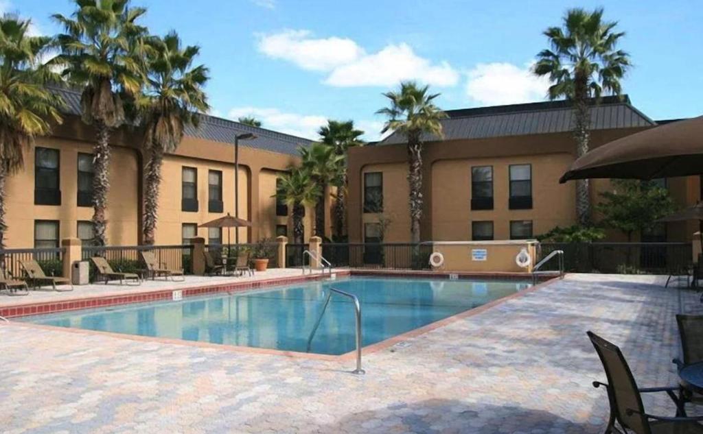 奥兰多Orlando Palms的棕榈树建筑前的游泳池