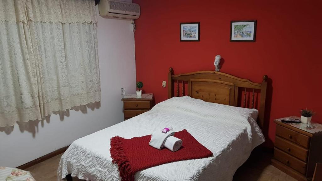 Bella UniónHotel Bella Unión的一间卧室配有一张红色墙壁的床