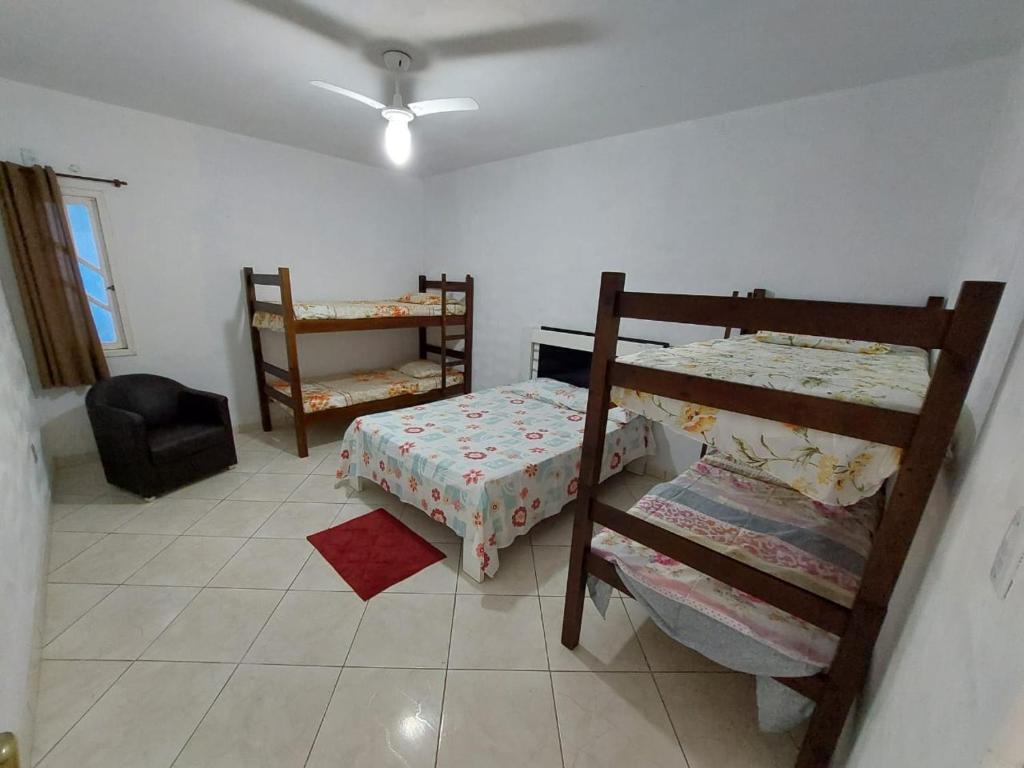TamoiosNacif&Alcantara Suítes的一间卧室配有两张双层床和椅子