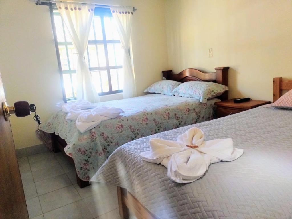 莱瓦镇ABI HAPPY的一间卧室配有两张带白色鲜花的床。