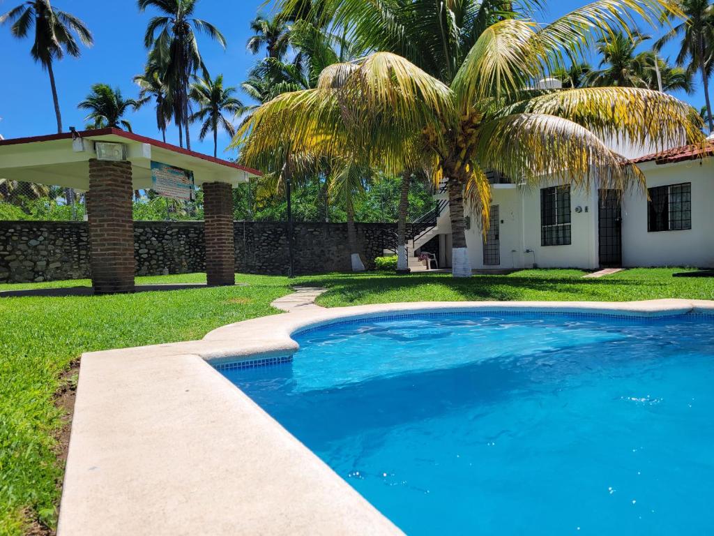 锡瓦塔塔内霍Casa de las Palmas的棕榈树屋前的游泳池