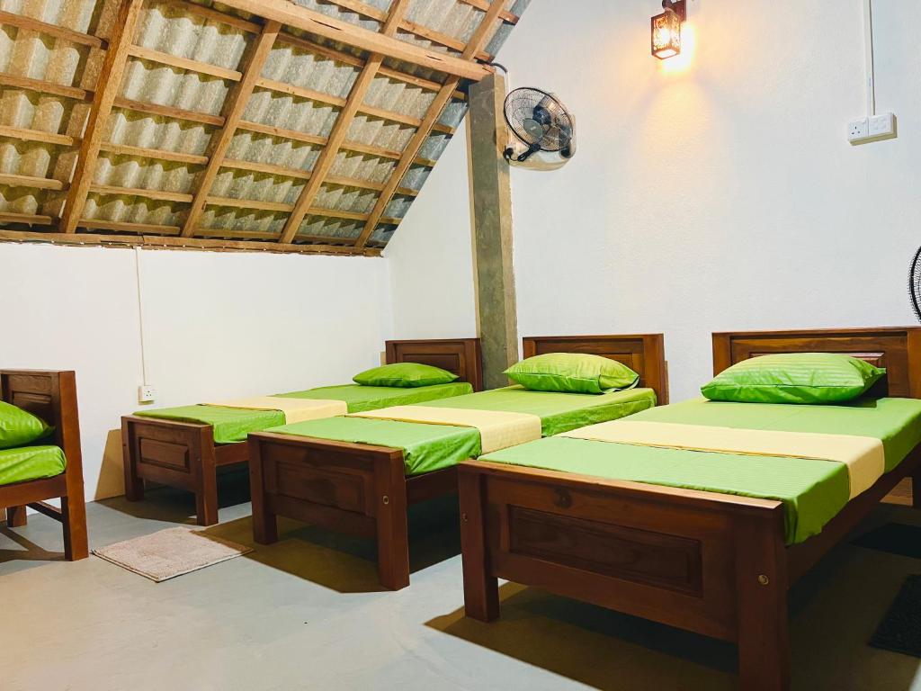 基林德Bay Vista-Yala的一间设有四张床及绿色靠垫的客房