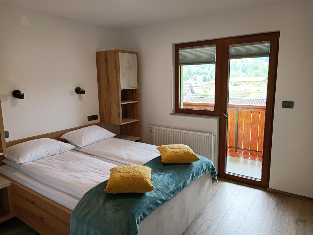 博希尼Apartmaji Hodak的一间卧室配有一张带两个黄色枕头的床