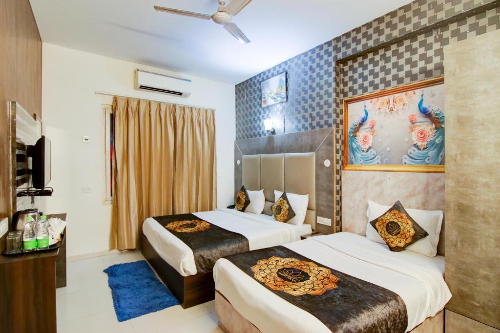 新德里Hotel HSP Suites At Delhi Airport的一间酒店客房,设有两张床和电视