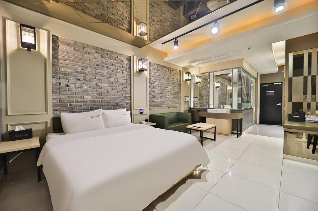 浦项Pohang A1 Jukdo的一间带白色大床的卧室和一间浴室