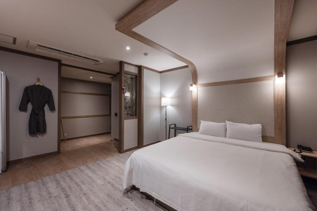 釜山O Hotel的卧室配有一张白色大床和浴袍