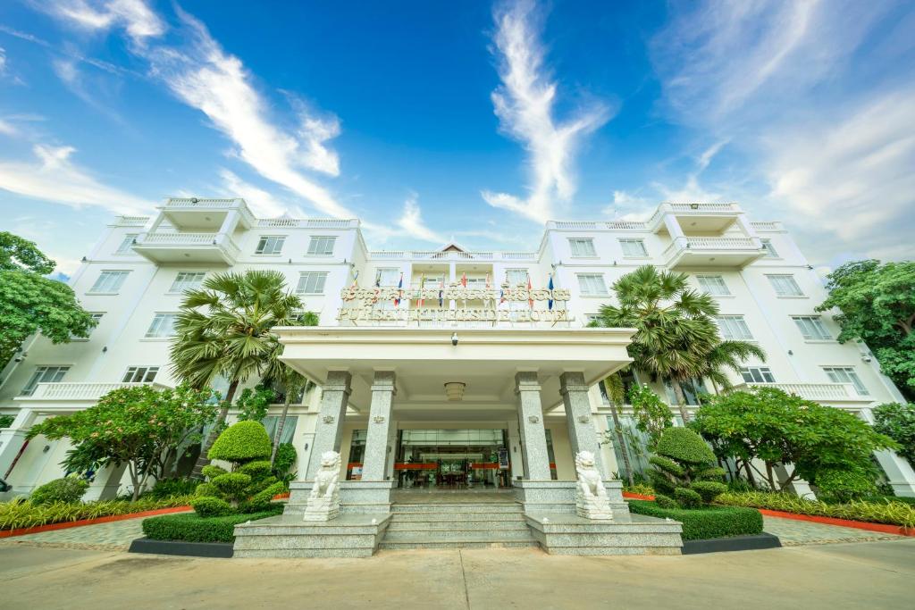 PursatPursat Riverside Hotel & Spa的一座白色的建筑,上面设有一个阳台