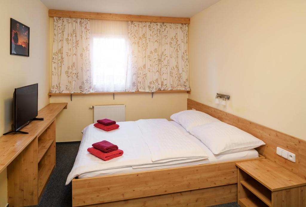 奥斯特鲁兹纳Horský Hotel Skiland的一间卧室配有一张带两个红色毛巾的床