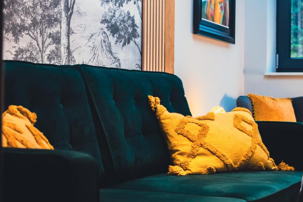 斯特日察Lubiński Resort的绿色沙发上配有黄色枕头