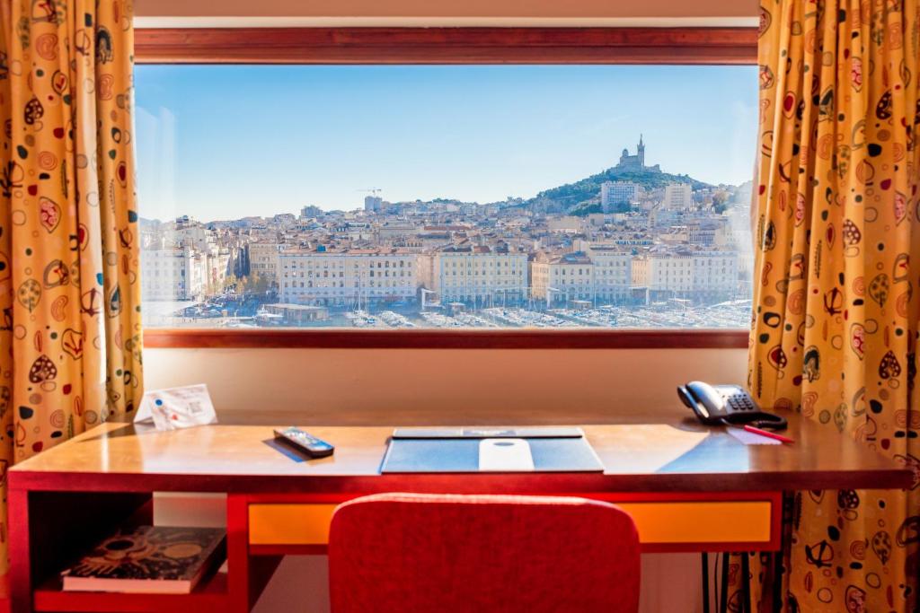 马赛老港口酒店的一张带窗户的书桌,享有城市美景