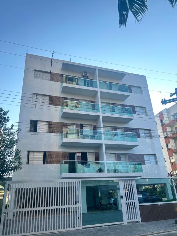 瓜鲁雅Apartamento Guaruja Enseada的一座高大的建筑,旁边设有阳台