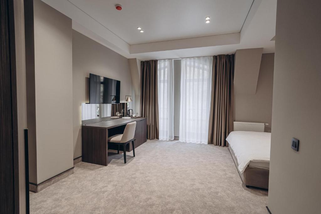 乌日霍罗德Park Hotel Bristol的配有一张床和一张书桌的酒店客房