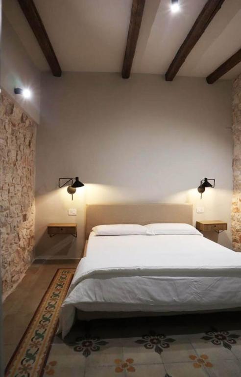 图里La Casetta b & b的卧室配有一张带两个灯的大白色床