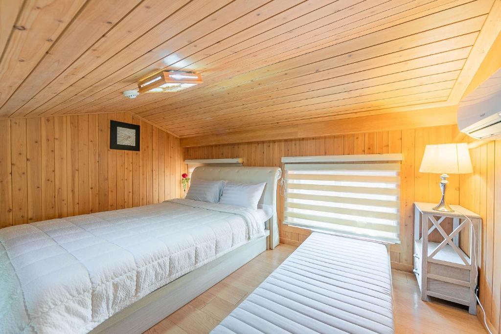 顺天市四季公寓的一间卧室设有一张床和木制天花板
