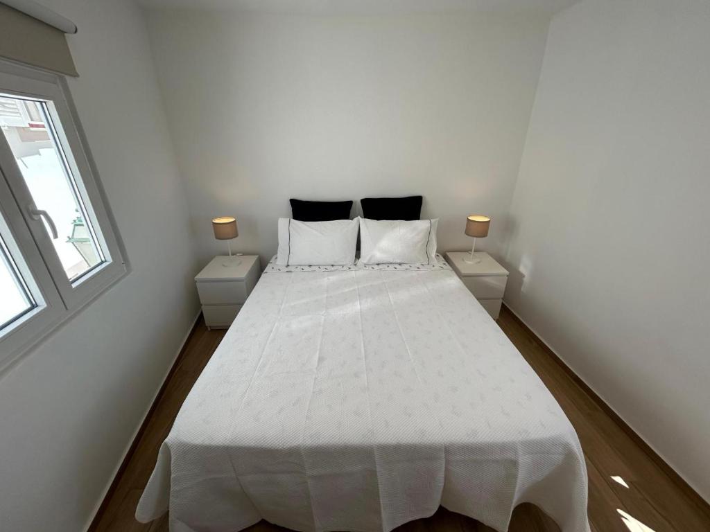 阿尔布费拉Vista del Mar Guest House的一间卧室配有白色床和2个床头柜