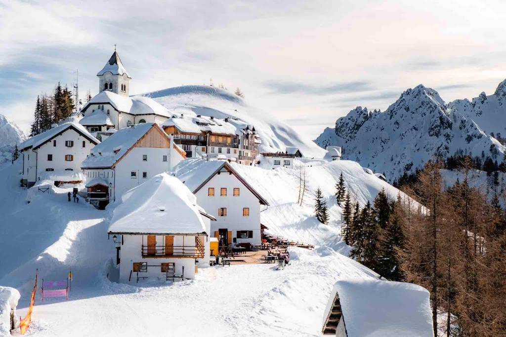 塔尔维西奥Liebehaus的雪中的小村庄,有教堂