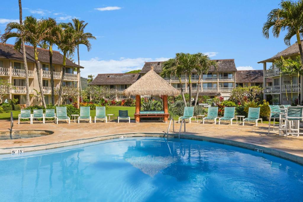 卡帕阿海滩雅诗顿艾兰德酒店的度假村的游泳池配有椅子和遮阳伞