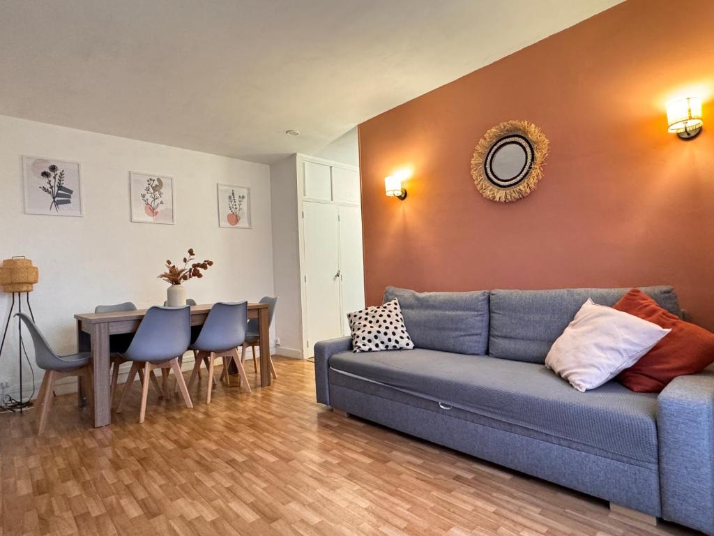 奥贝维利埃Appartement F3 15 mins à Paris的客厅配有蓝色的沙发和桌子