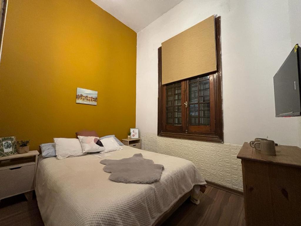蒙得维的亚Expreso terminal的一间卧室设有一张黄色墙壁和窗户的床