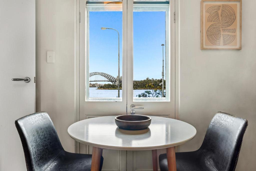 悉尼Balmain Wharf 1 bedroom Apartments的桌子上的碗,椅子和窗户