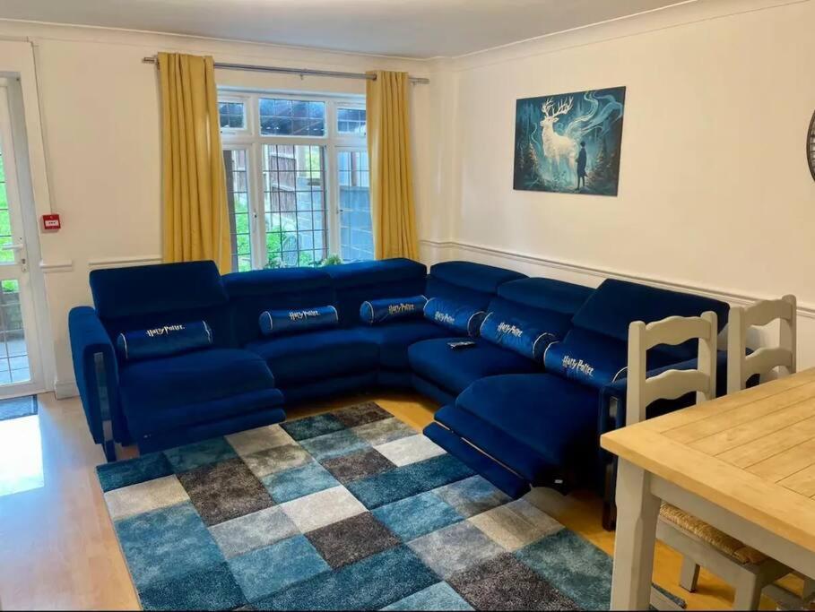 沃特福德Spacious 5 Bedroom House- Harry potter world & London的客厅配有蓝色的沙发和桌子