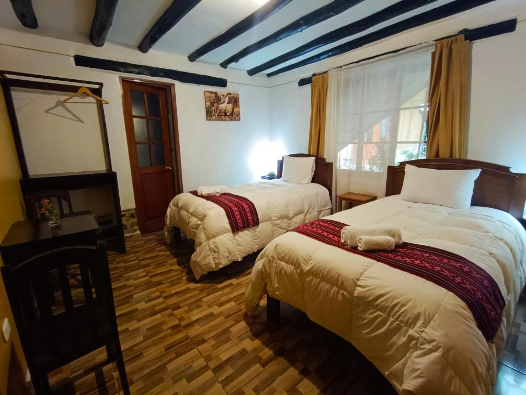 奥兰太坦波维拉斯旅馆的酒店客房设有两张床和窗户。