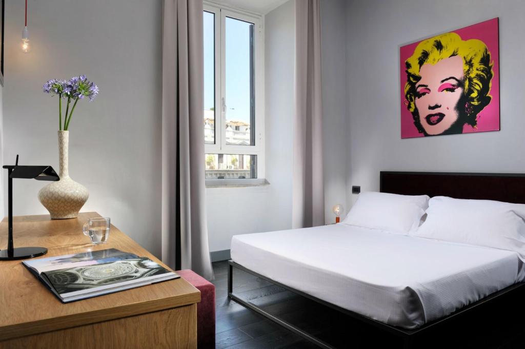 罗马艺术纳沃纳套房的酒店客房配有一张床和一张桌子以及一张桌子。