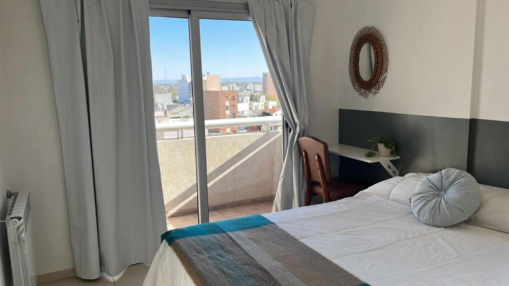 里奥夸尔托Rio Apart Imperio的一间卧室设有一张床,享有阳台的景色