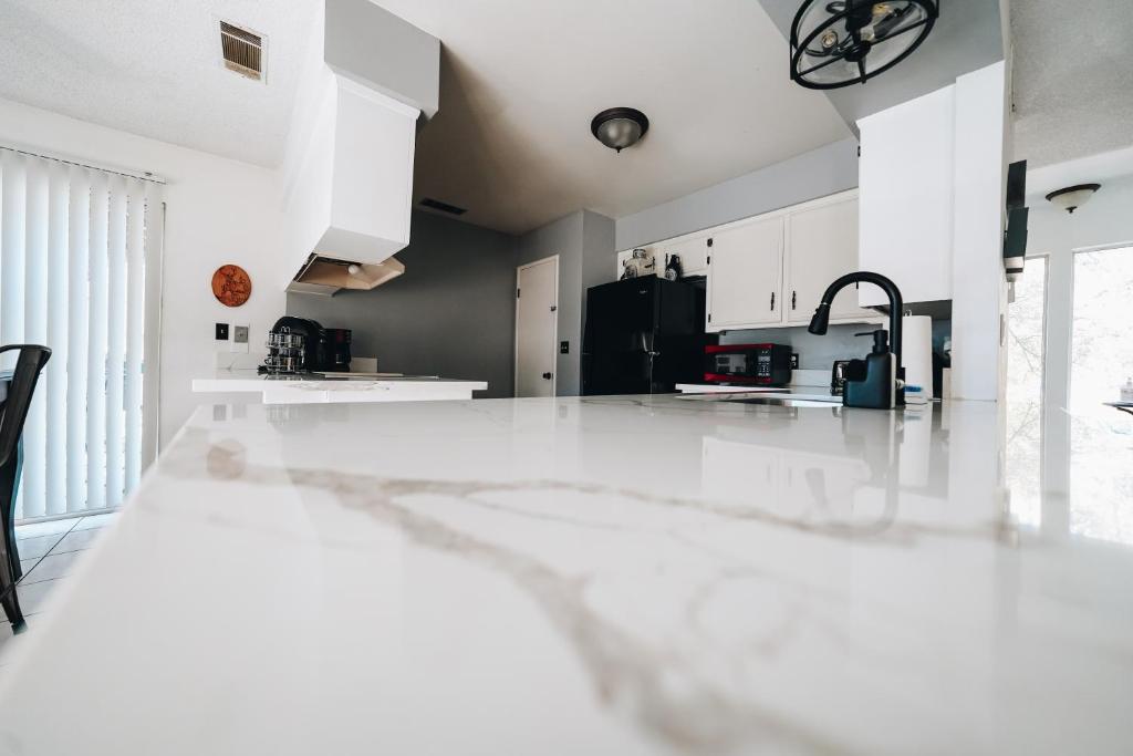 三河城Pebble Creek的厨房配有白色橱柜和黑色冰箱。