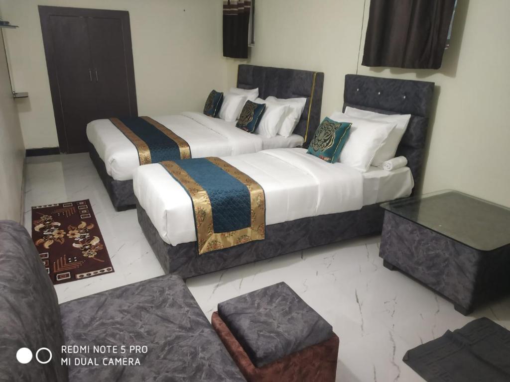 PannaHotel Kumkum Chhaya的带沙发的客房内的两张床