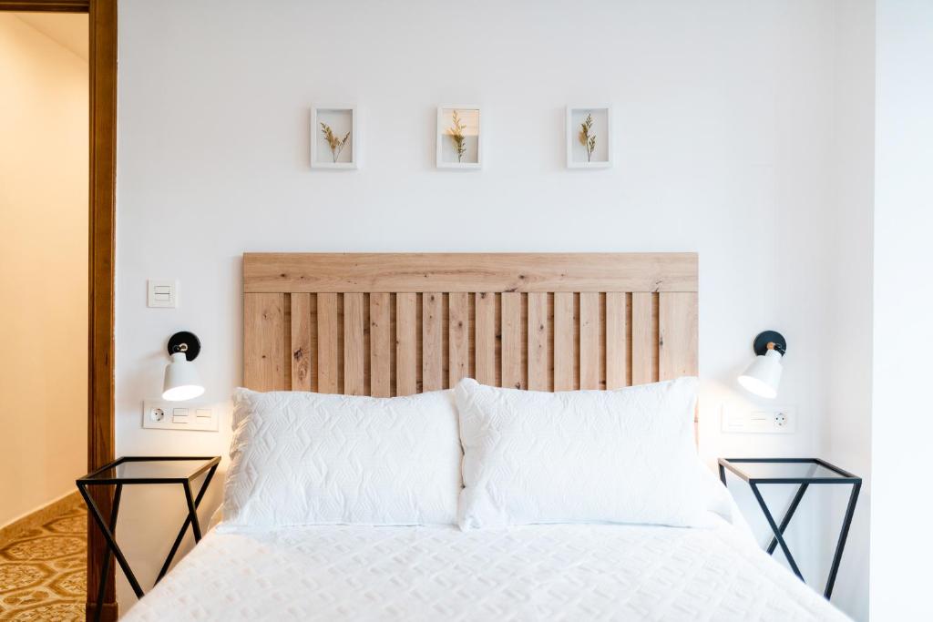 格拉纳达Piso junto a Parque de las Ciencias en Granada的一间卧室配有一张带两盏灯的大型白色床。