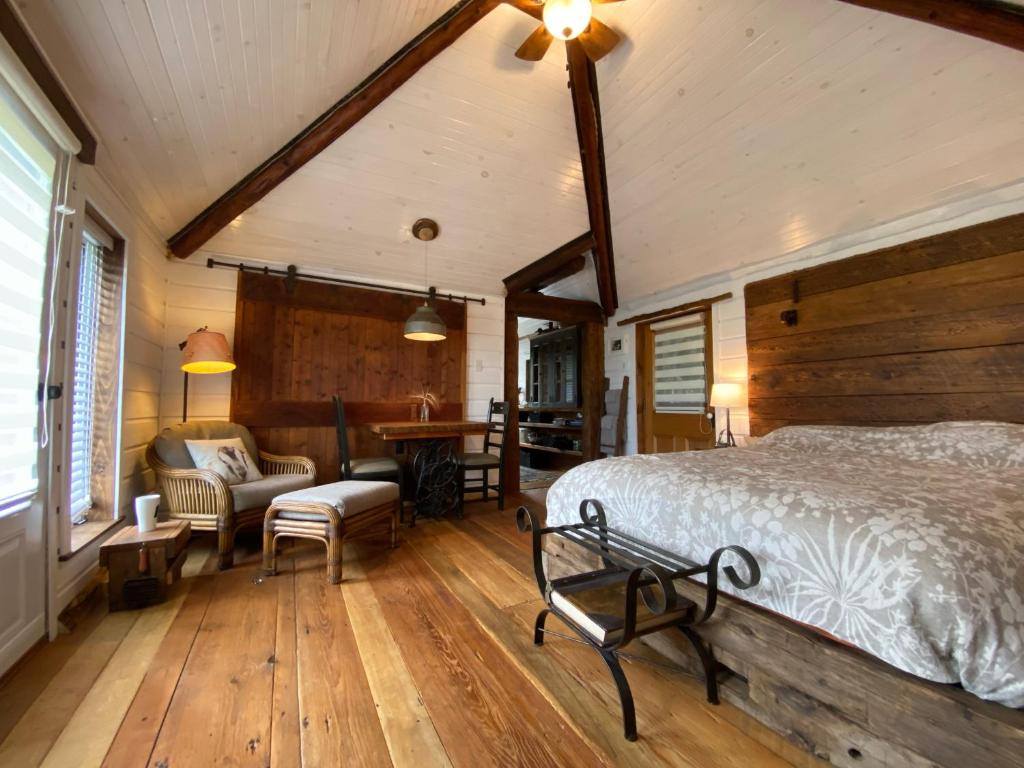 OrmstownEco Lodge Bûcheron Bergère的一间卧室配有一张床、一张沙发和一张桌子