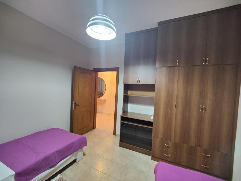 培拉特City Center Apartment的一间卧室配有紫色的床和木制橱柜