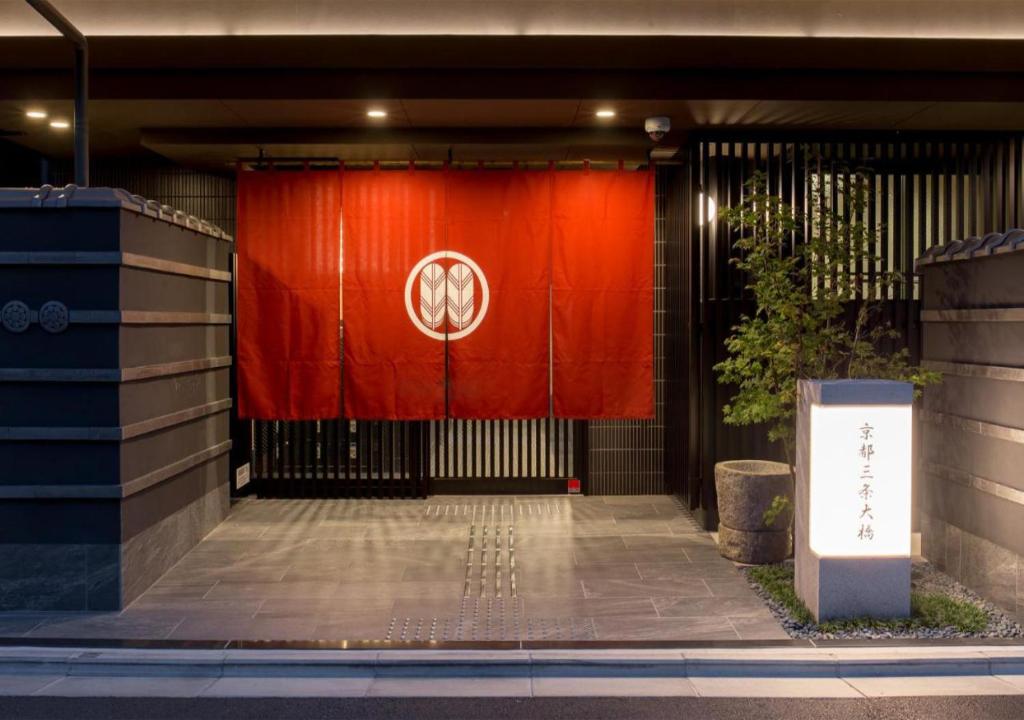 京都Kyoto Sanjo Ohashi的大楼前有标志的红色门