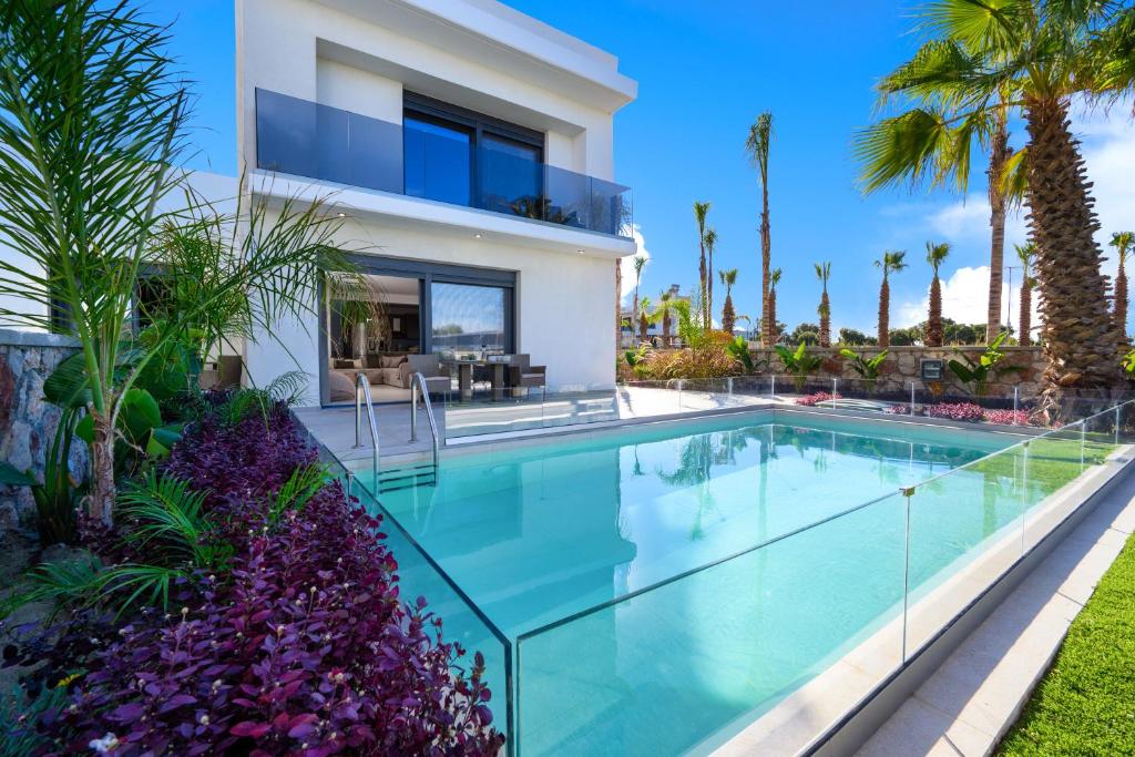 克雷马斯蒂Penélope Beachfront Villa的一座别墅,设有游泳池和棕榈树