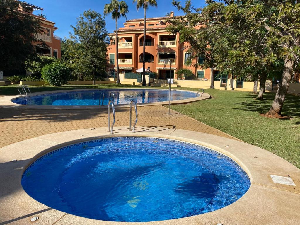 哈维亚La Gavina Loft Xàbia & ARCADE的一座蓝色的大游泳池,后面是一座建筑