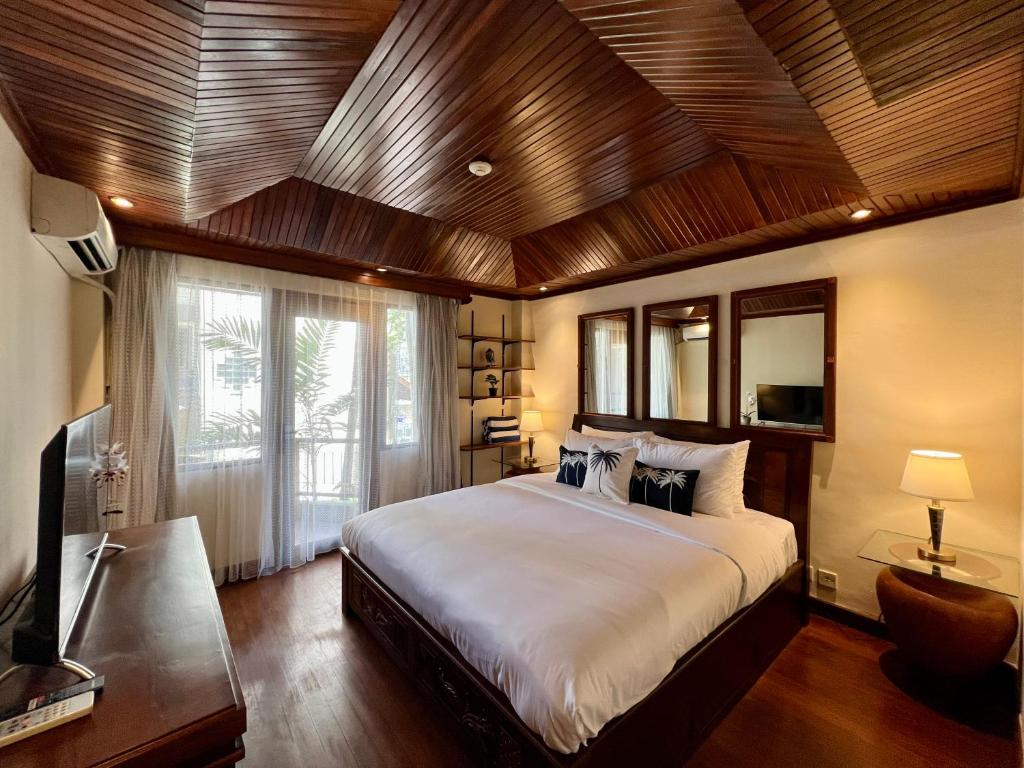 塞米亚克Galayanee’s Resort Apartment的一间卧室设有一张带木制天花板的大床