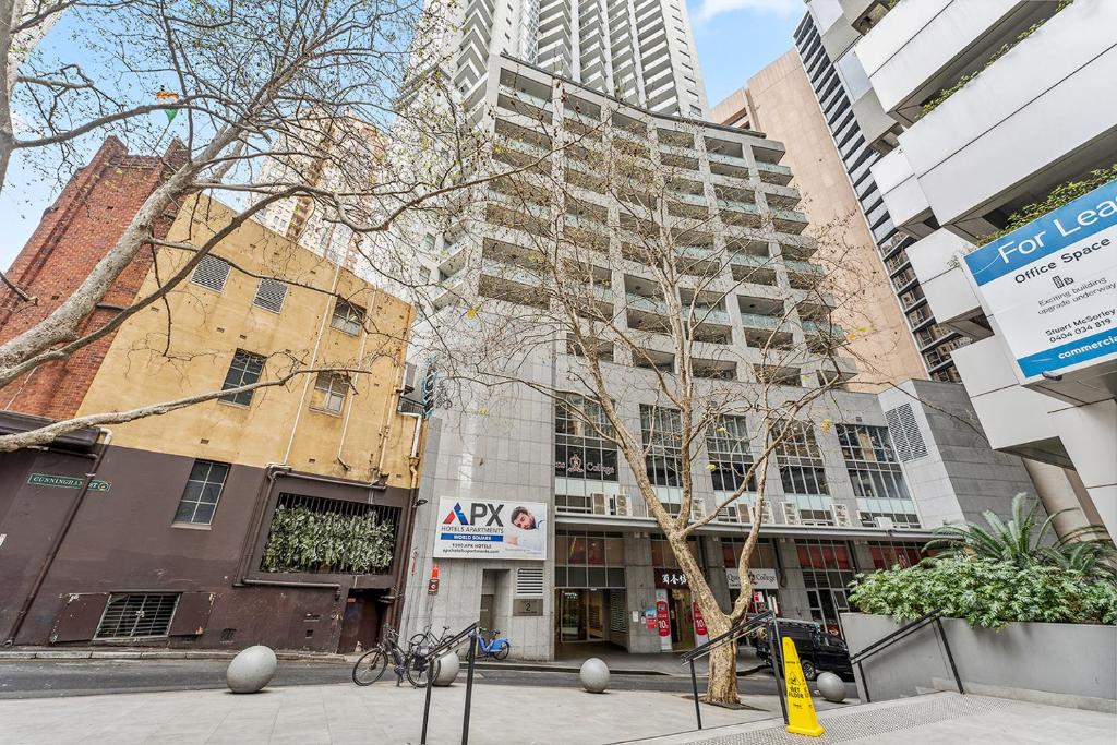 悉尼APX世界广场公寓式酒店的一条城市街道,上面有高大的建筑和自行车停放在人行道上