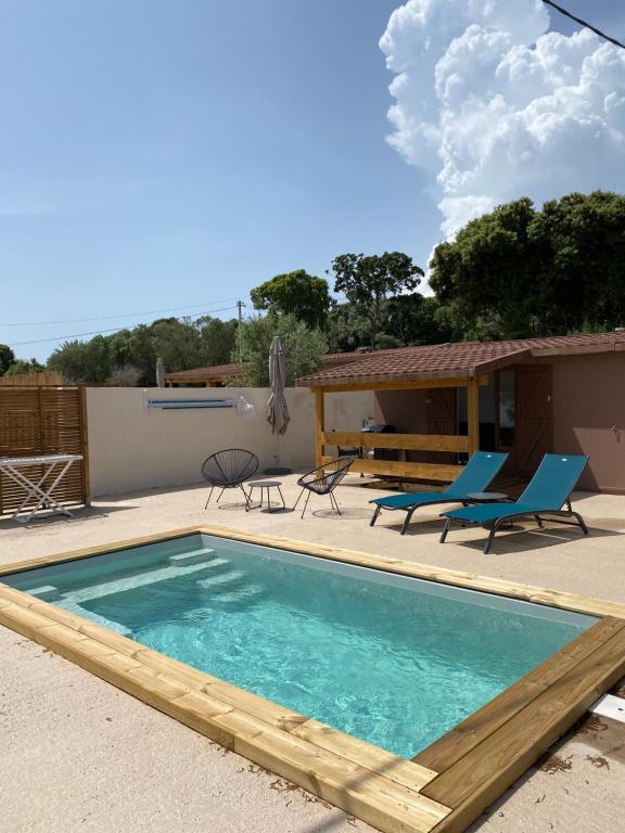 博尼法乔Petit chalet d’été avec piscine privée chauffée的一个带蓝色椅子的游泳池